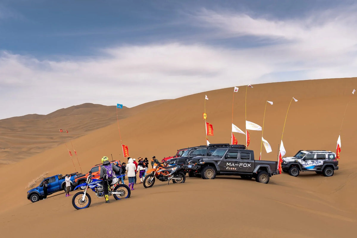 Off-road vehicles, motorcycles and people gathered on sand dunes — Badain Jaran Desert, Inner Mongolia, China, 2023