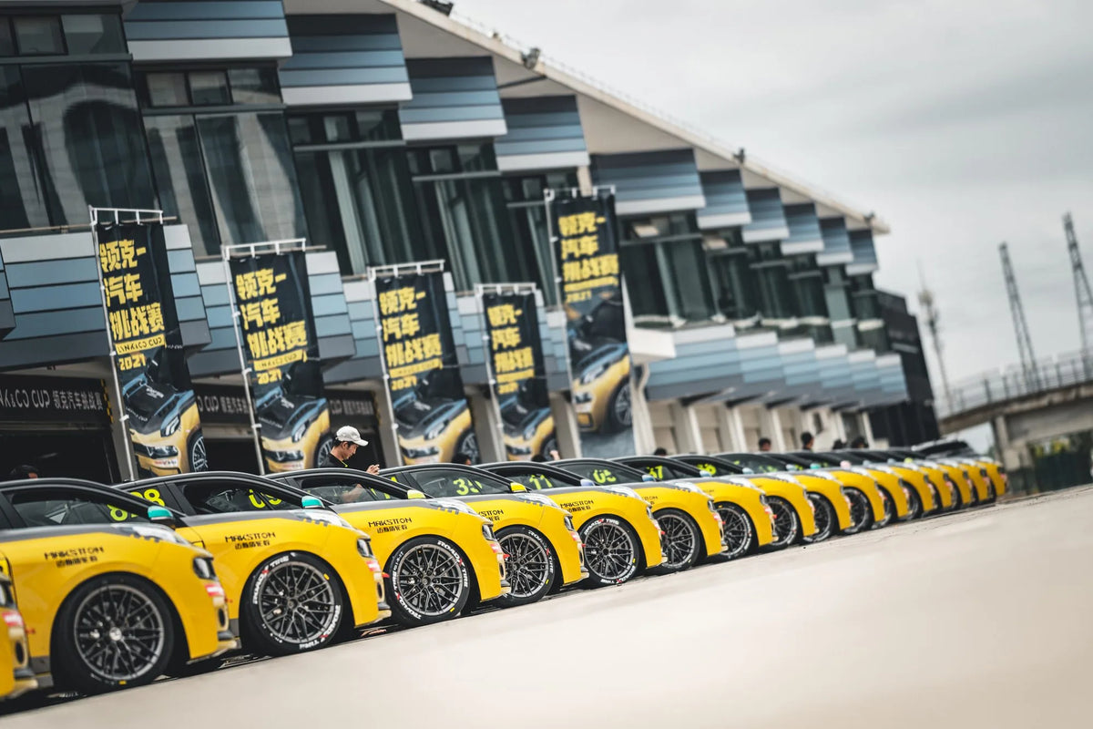 A lineup of yellow Lynk & Co race cars outside the pit garages — Lynk & Co Challenge, China, 2021