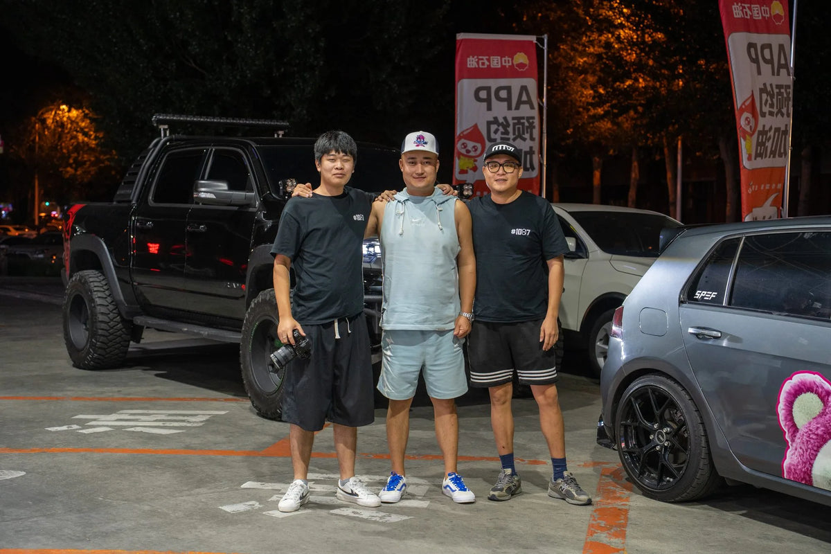 Three people beside modified cars and a black off-road vehicle at night — SKYBRK · SHENYANG, Liaoning, China, 2023