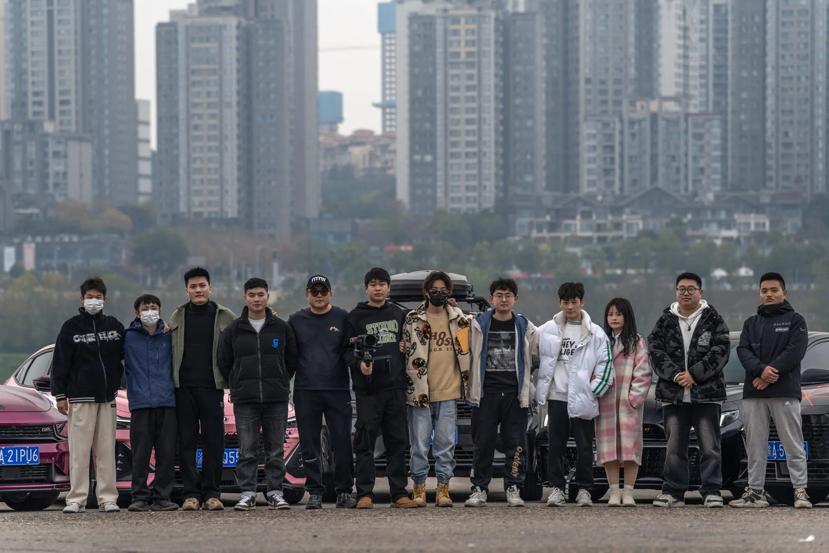 MAKSTTON owners gathered beside their cars with city buildings behind them — Chongqing, Chongqing, China, 2024